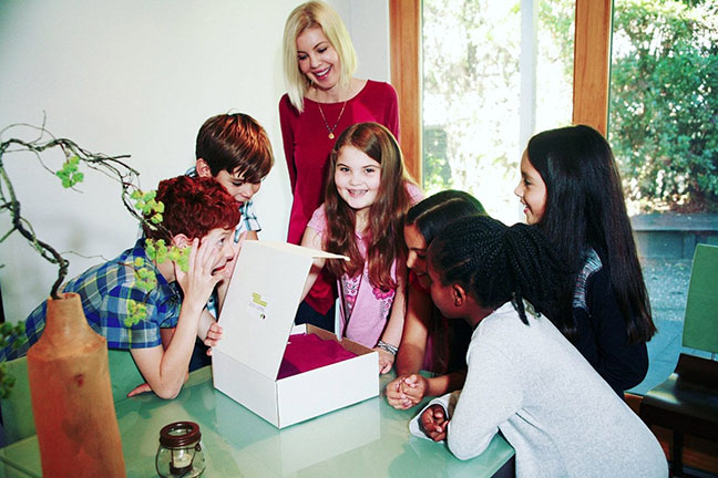 A group of children looking at a box.