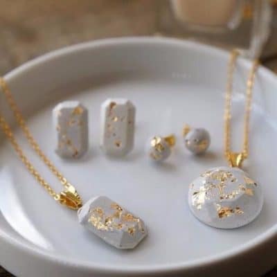 A white and gold jewelry set on a plate.