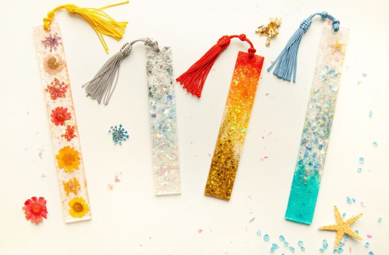 A group of colorful bookmarks with tassels and seashells.