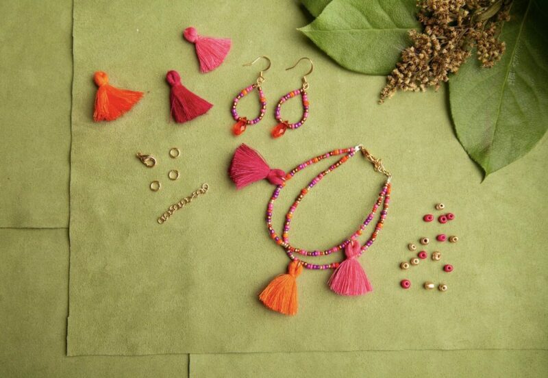 Tassels, beads, and other jewelry are laid out on a green leaf.