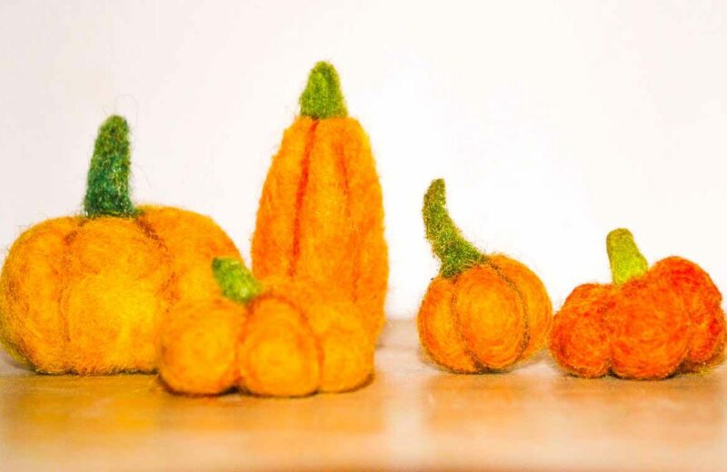 A group of felt pumpkins on a table.