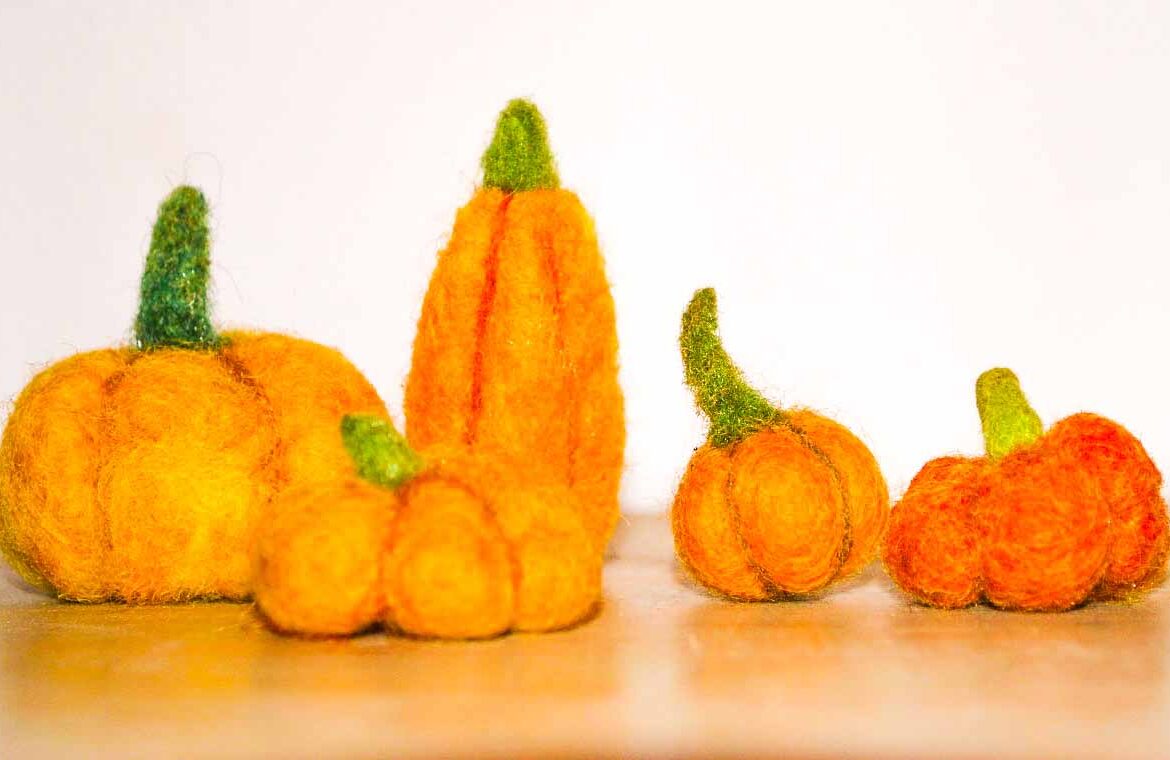 A group of felt pumpkins on a table.