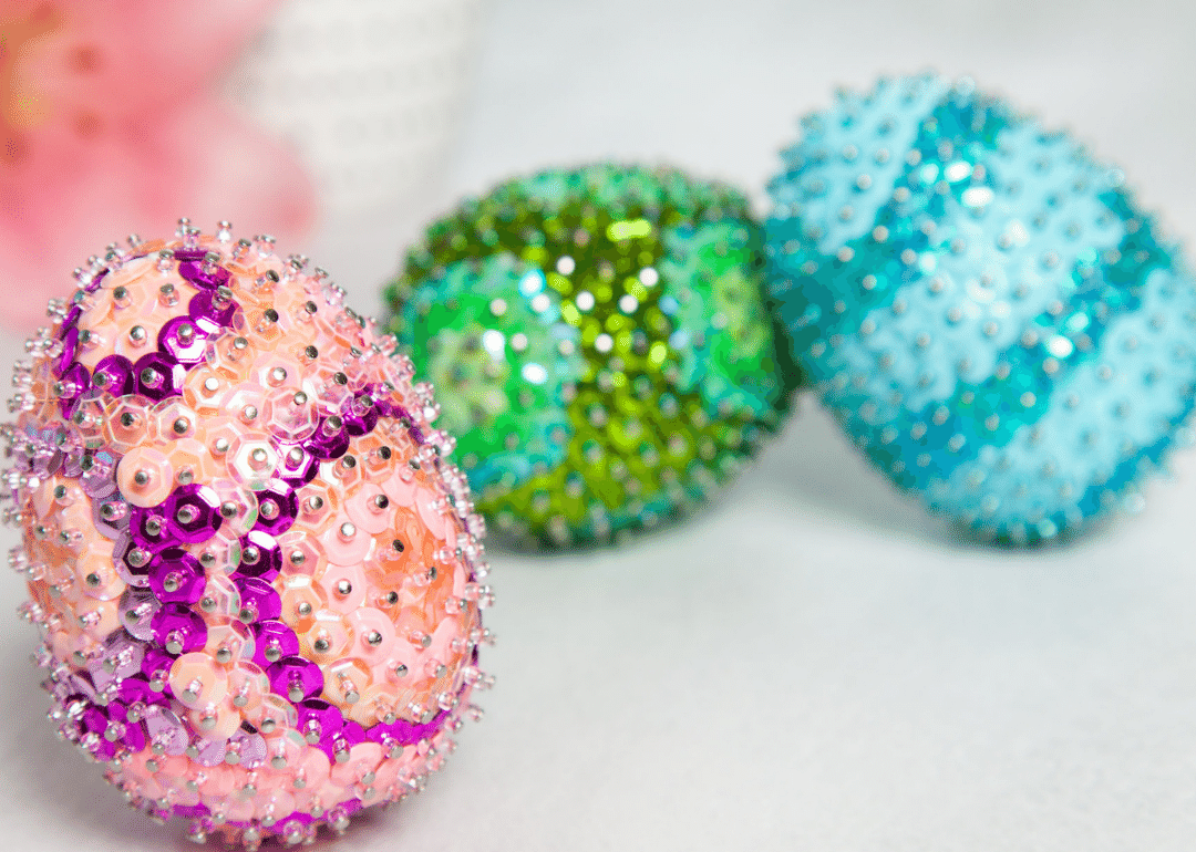 Three sequin easter eggs sitting on a table.