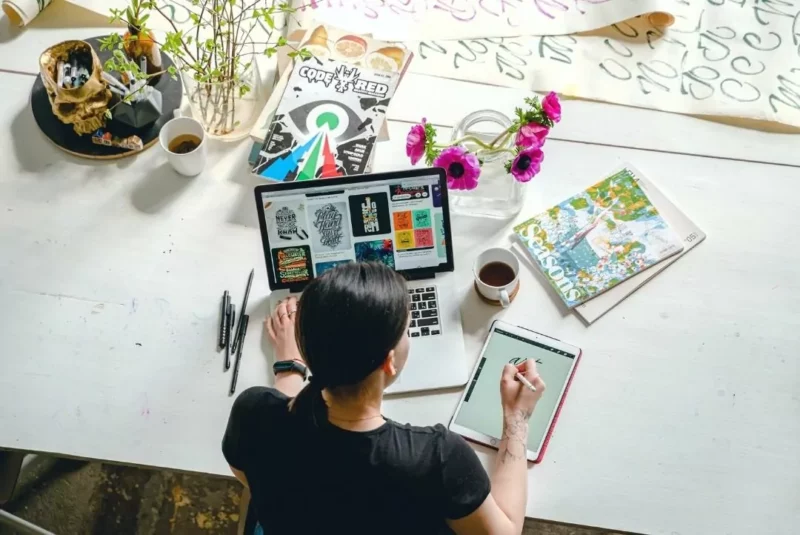 A woman working at a desk with a laptop.