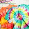Tie dye t - shirts on a white surface.