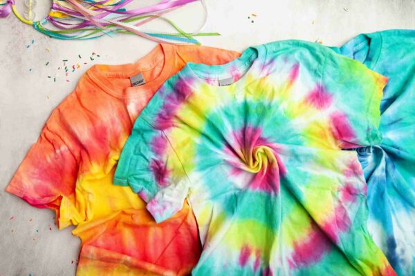 Tie dye t - shirts on a white surface.