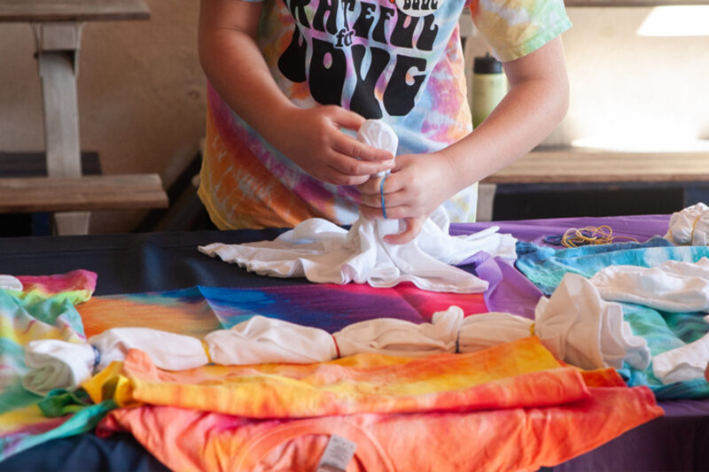 A young boy putting clothes on a table.