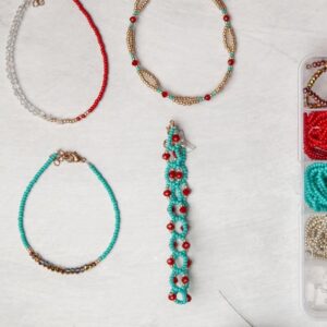 A box of beads and bracelets on a table.