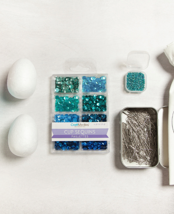 Easter egg craft kit with blue beads and a tin.
