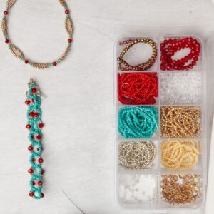A box of beads, beads and tassels on a table.
