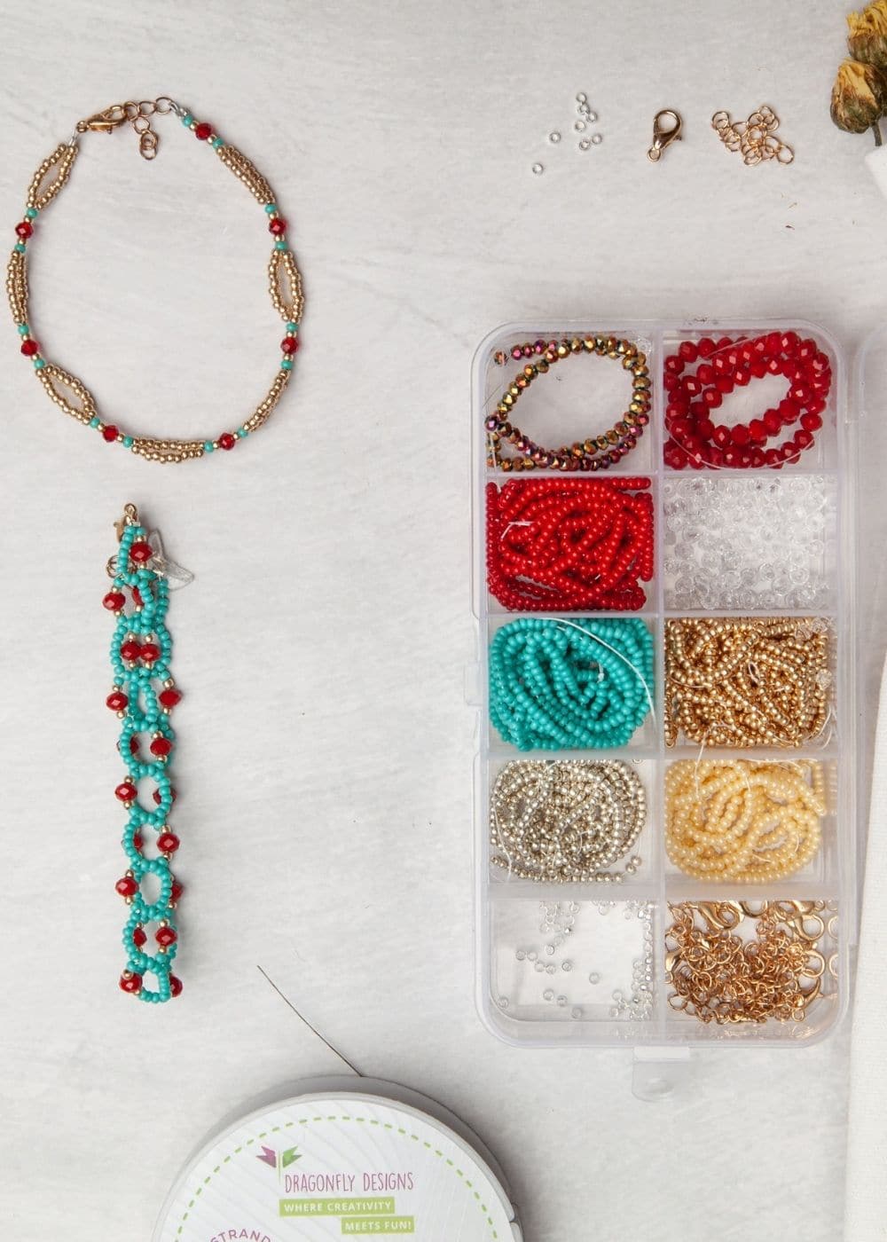 A box of beads, beads and tassels on a table.