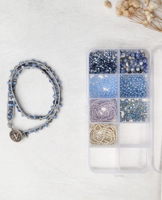 A clear box with blue beads and a bracelet.