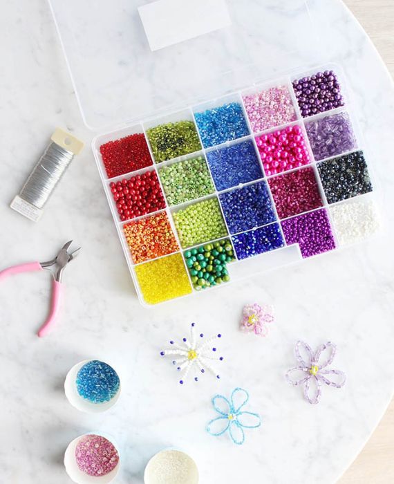 A tray of colorful beads and scissors on a table.
