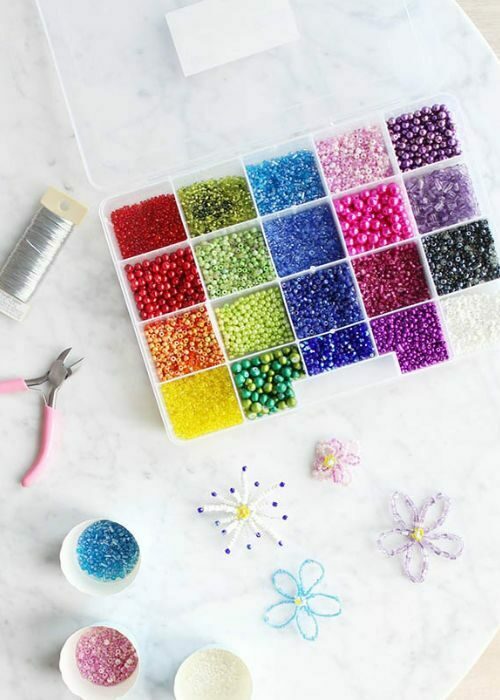 A tray of beads and scissors on a table.