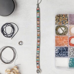 A beading kit with a variety of beads on a table.