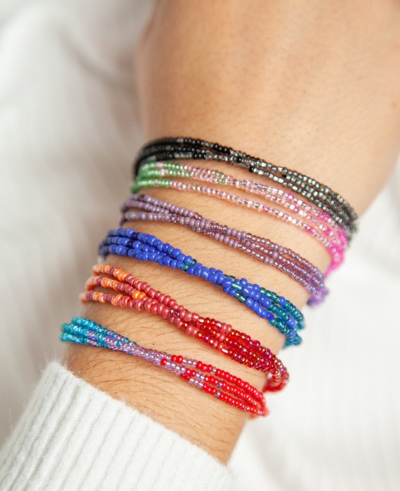 A woman's wrist with colorful beaded bracelets on it.