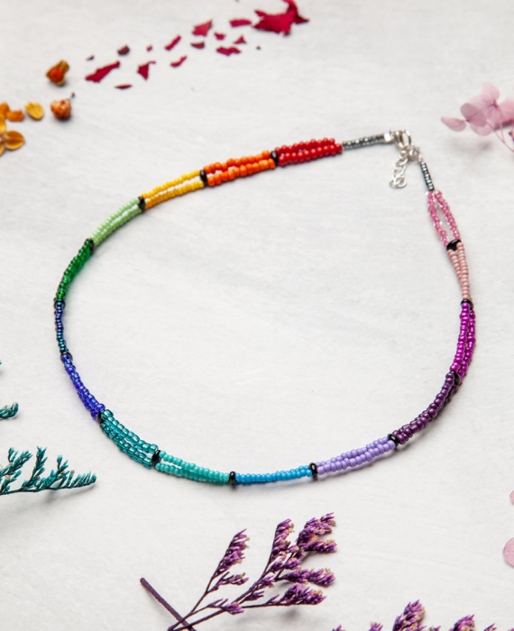 A rainbow colored necklace with flowers on it.