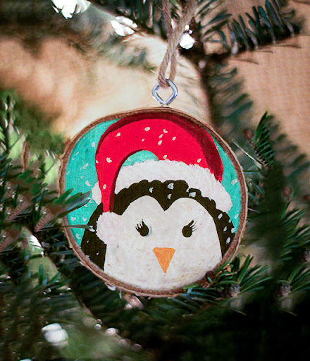 A penguin ornament hanging from a christmas tree.