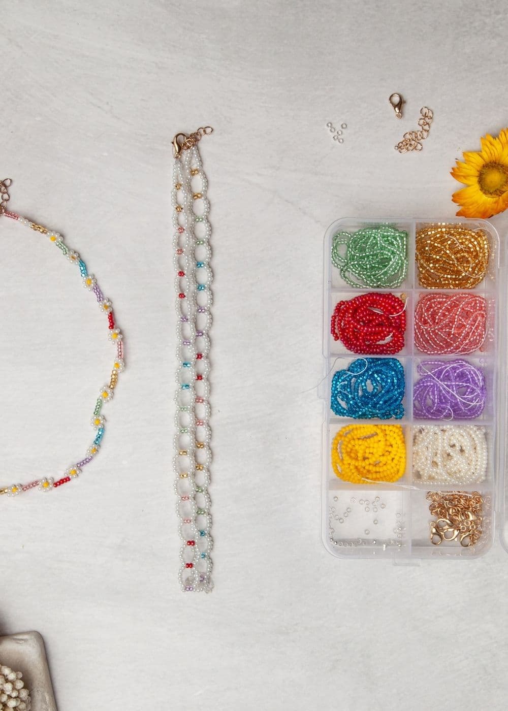 A jewelry making kit with beads and a flower.