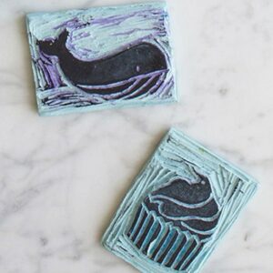 Two blue and white rubber stamps with a whale on them.