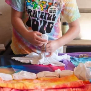 A girl is making a Kids Tie-Dye Party - San Diego Area t-shirt.