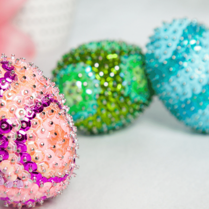 Three sequin easter eggs sitting on a table.